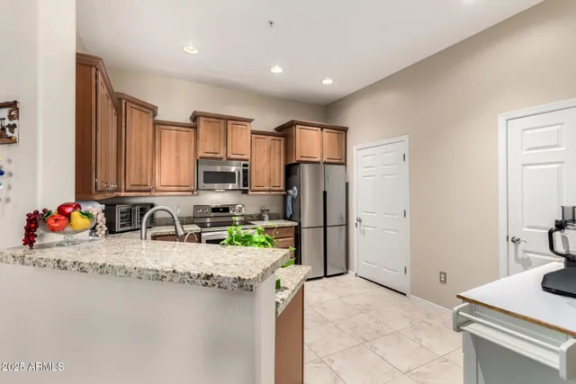 a kitchen with stainless steel appliances granite countertop a sink refrigerator and cabinets