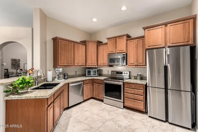 a kitchen with stainless steel appliances granite countertop a stove a sink dishwasher a refrigerator and a microwave