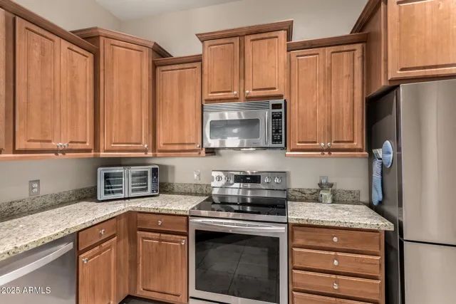 a kitchen with stainless steel appliances granite countertop a sink stove and refrigerator