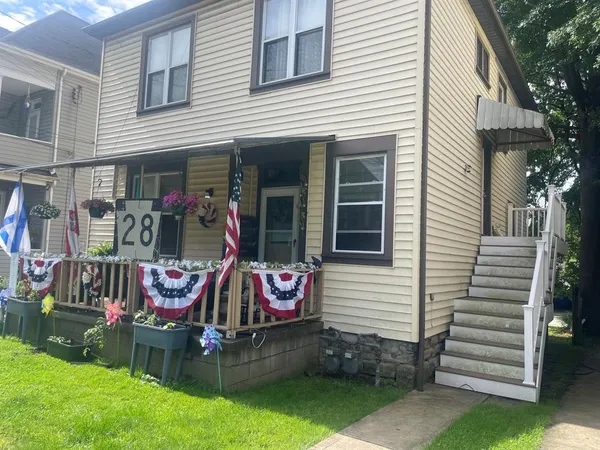 a front view of a house with garden and patio