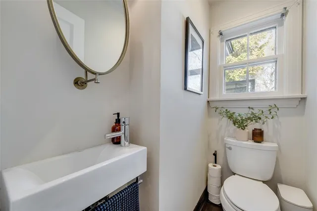 a bathroom with a sink a toilet and a mirror