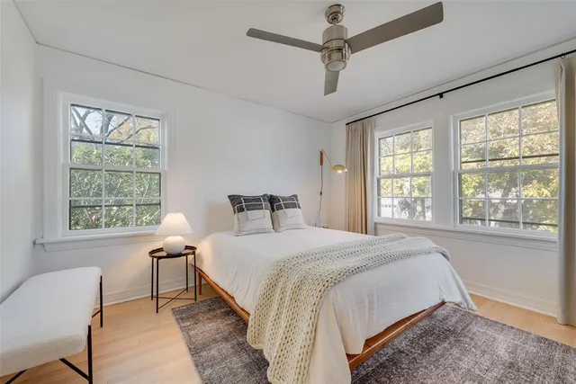 a spacious bedroom with a bed and a chair