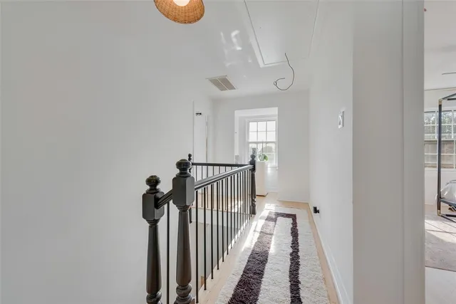 a view of a hallway with wooden floor and door