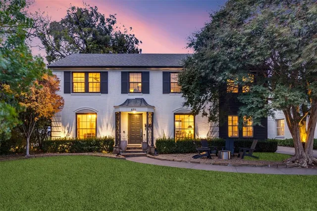 a front view of a house with a garden and plants