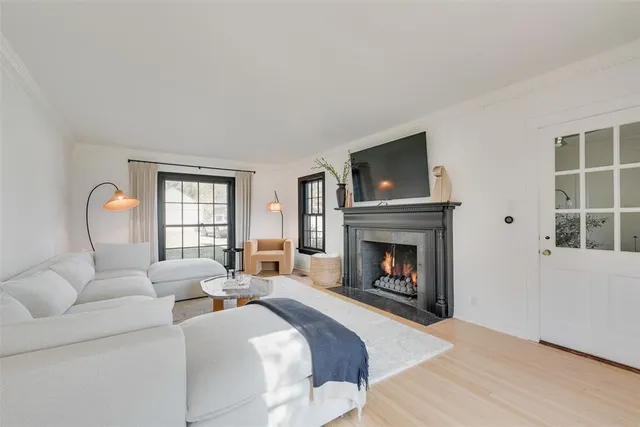 a living room with furniture a fireplace and windows