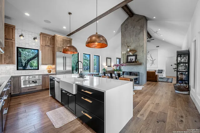 a large kitchen with stainless steel appliances kitchen island granite countertop a large island in the center