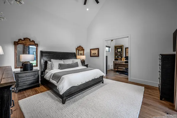 a spacious bedroom with a bed and wooden floor