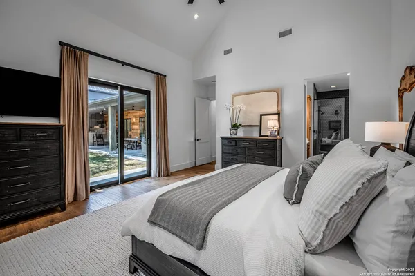 a bedroom with a bed and a flat tv screen on dresser