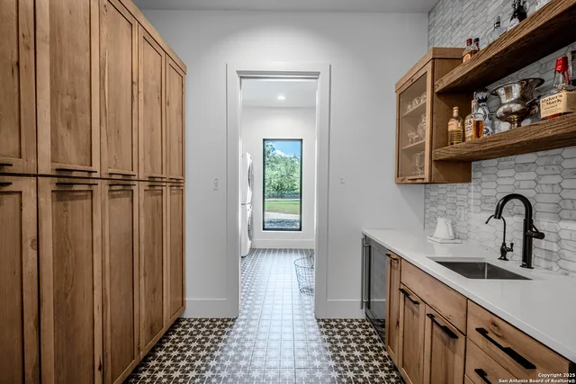 a kitchen with a sink a refrigerator and cabinets