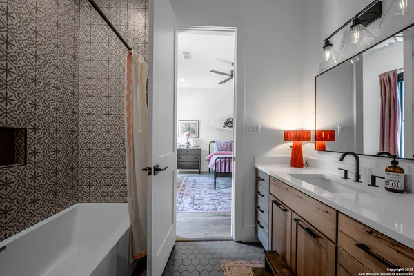 a bathroom with a double vanity sink a mirror and a bathtub