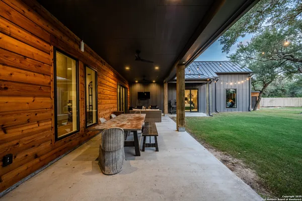 a view of a patio with table and chairs and a large tree