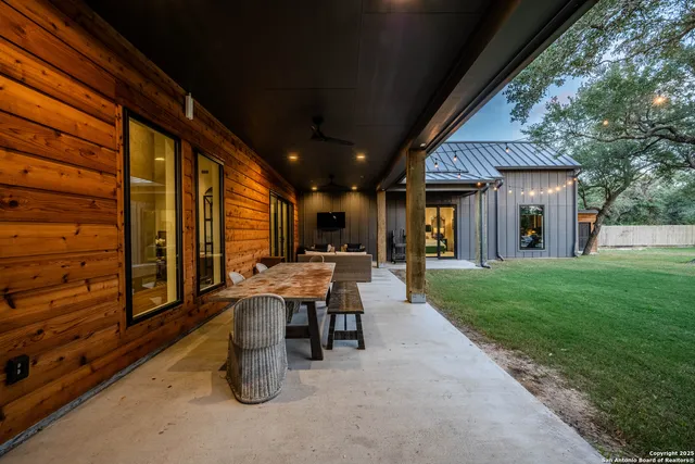 a view of a patio with table and chairs and a large tree