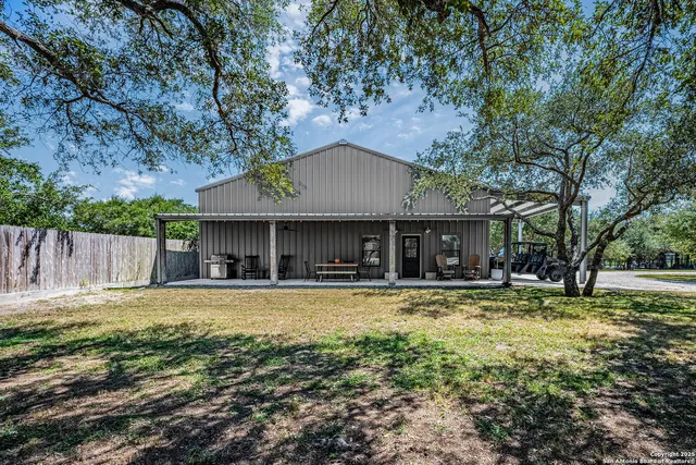 a view of a house with a yard patio and fire pit