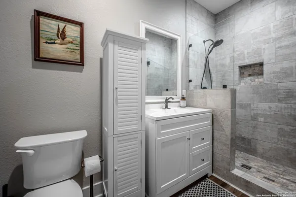 a bathroom with a sink mirror vanity and toilet