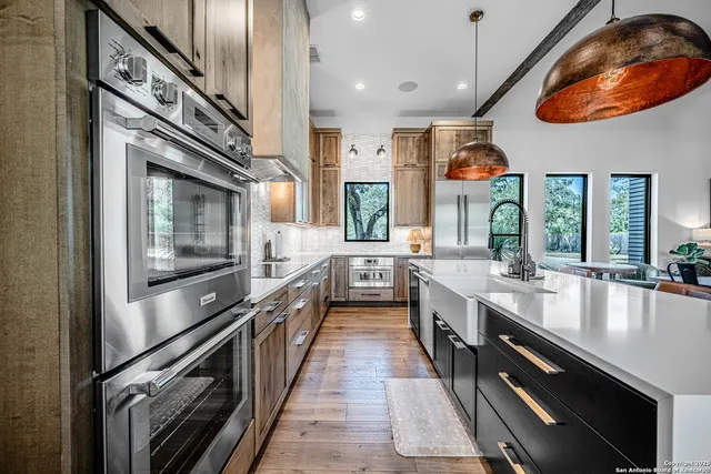 a large kitchen with stainless steel appliances granite countertop a lot of counter space