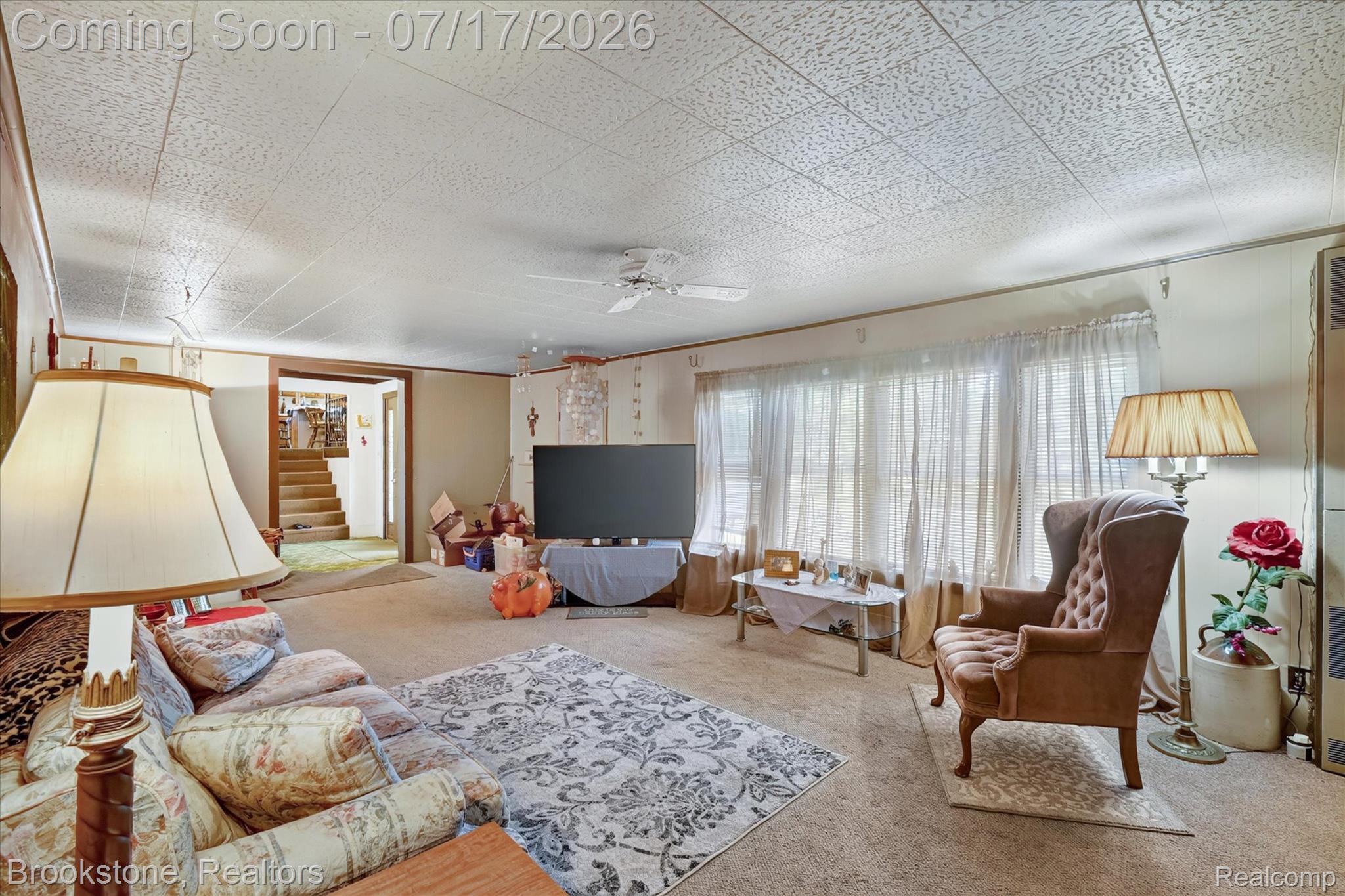 22025 Lakefield Road Merrill, MI 48637 - Photo 7 of 47 Carpeted living space featuring a textured ceiling, a ceiling fan, and multiple windows with sheer white coverings