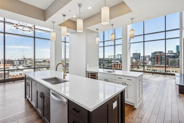 a kitchen with stainless steel appliances granite countertop a sink a stove and a wooden floors