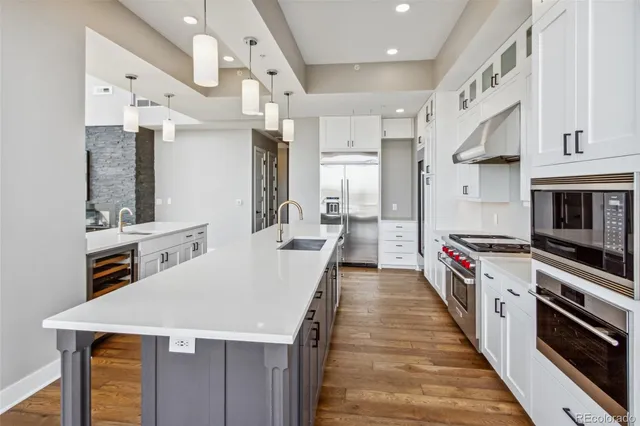 a kitchen with stainless steel appliances granite countertop a sink a stove and a refrigerator