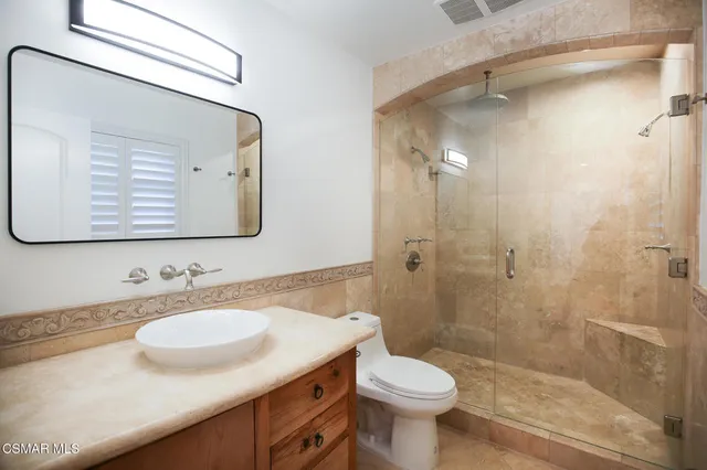 a bathroom with a sink a toilet and shower