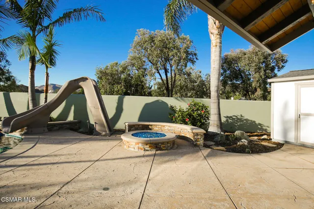 a view of backyard with a patio and a fire pit