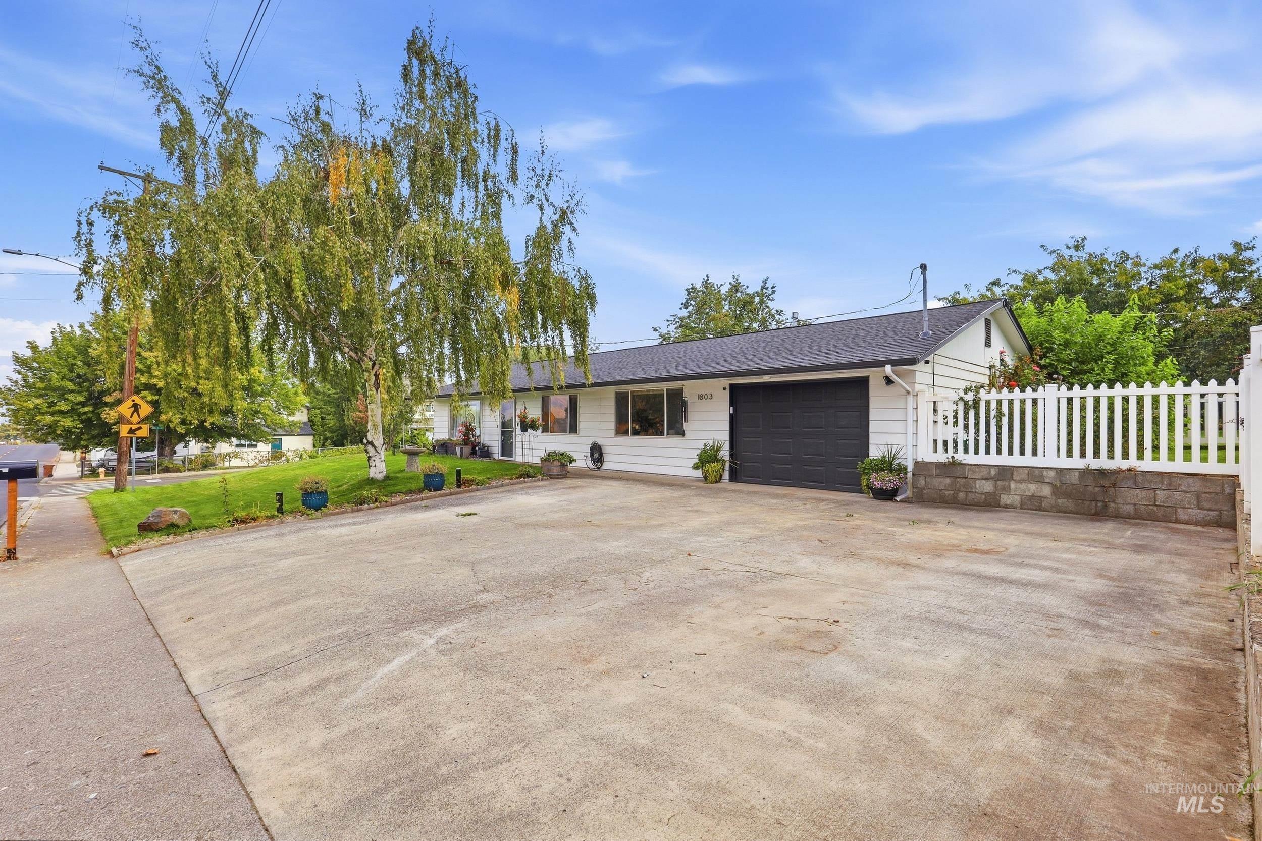 1803 14th Street Lewiston, ID 83501 - Photo 3 of 27 Single-story residence featuring a dark shingle roof, white siding, and an attached garage with a dark door