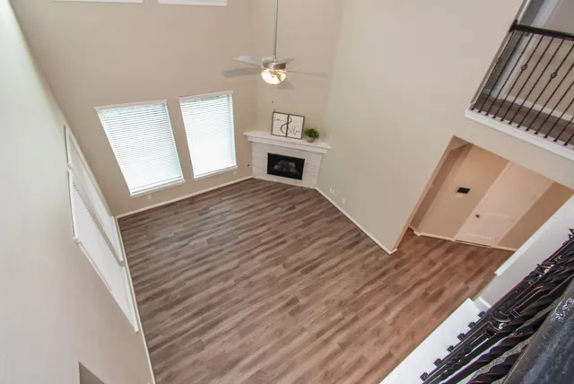 a view of a livingroom with wooden floor and staircase