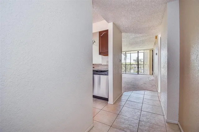 a view of kitchen with stainless steel appliances wooden cabinets and stove top oven