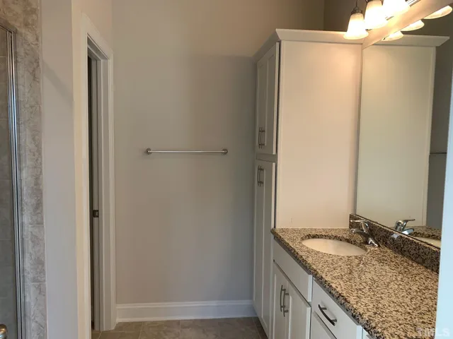 a bathroom with a granite countertop sink and a mirror