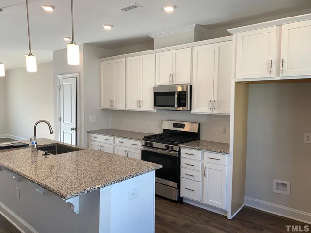 a kitchen with stainless steel appliances granite countertop a sink a stove and a granite counter tops