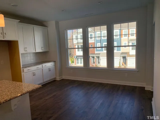 a kitchen with wooden floors and white cabinets