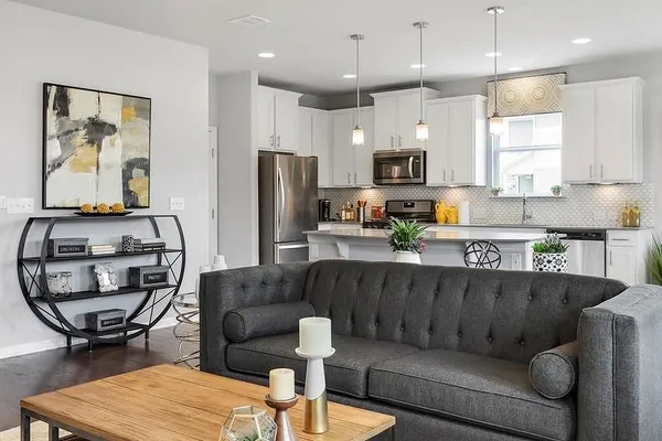 a living room with furniture and a dining table with kitchen view