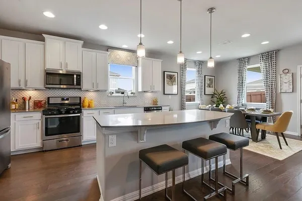 a large kitchen with kitchen island a dining table and chairs