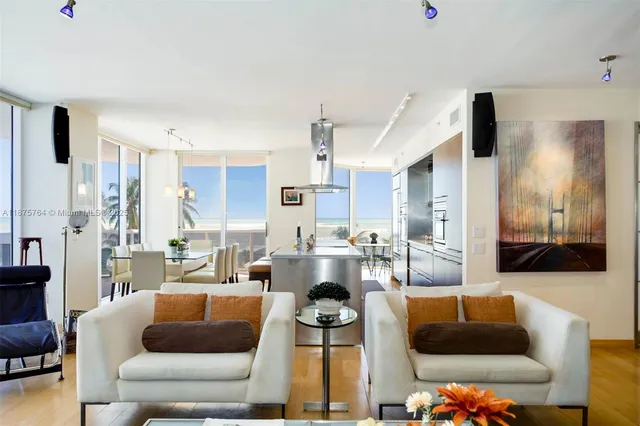 a living room with furniture and a view of kitchen