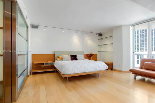 a spacious bedroom with a bed and a dresser