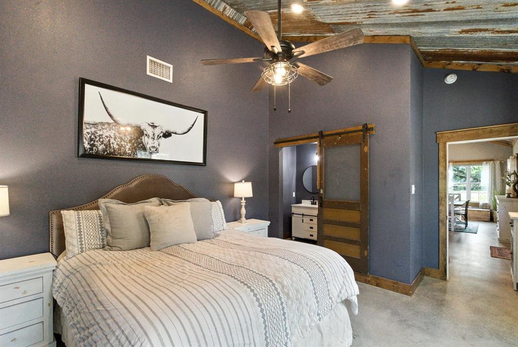 11140 Light Road Lipan, TX 76462 - Photo 18 of 37 a bedroom with a bed and a chandelier