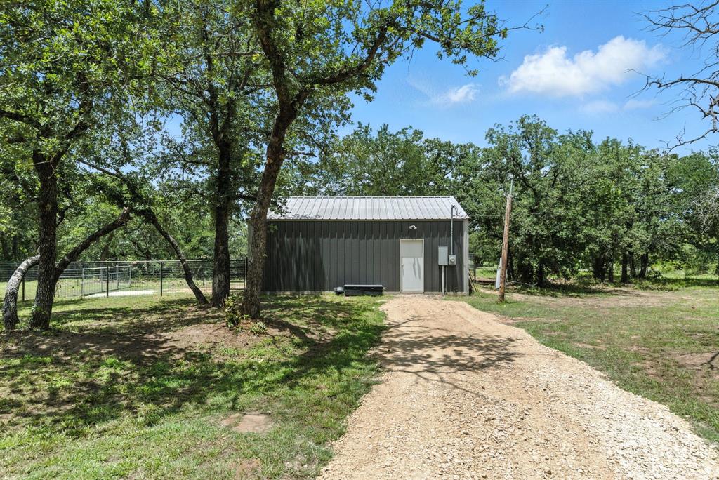 11140 Light Road Lipan, TX 76462 - Photo 32 of 37 a front view of a house with a garden and trees