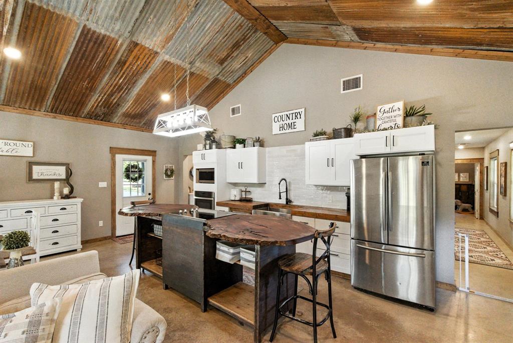 11140 Light Road Lipan, TX 76462 - Photo 10 of 37 a kitchen with stainless steel appliances refrigerator stove dining table and chairs