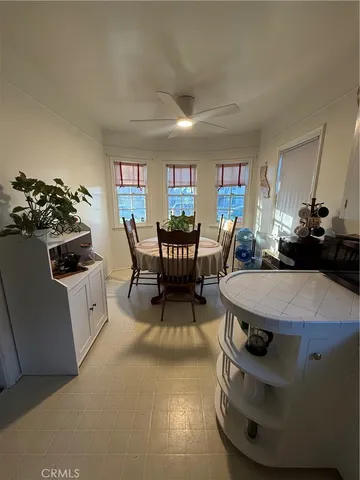 a living room with furniture a piano and a bookshelf
