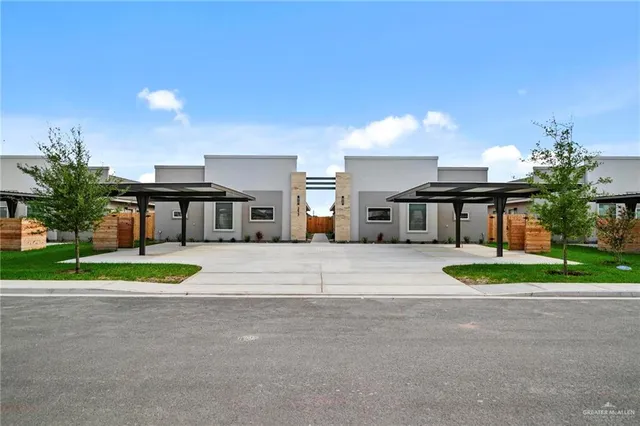 a white house with a yard plants and a big yard