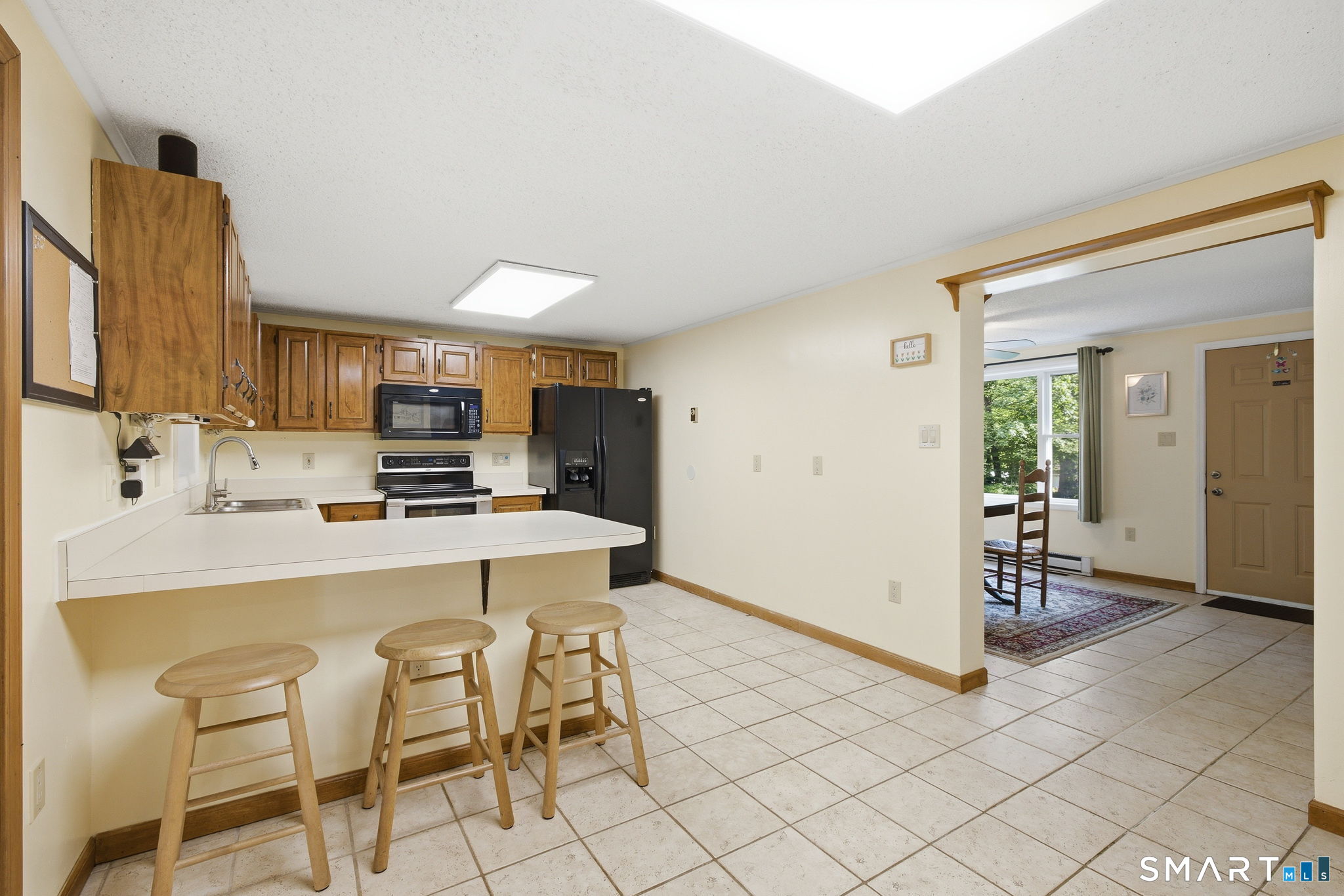 141 Hop River Road Coventry, CT 06238 - Photo 8 of 40 a kitchen with stainless steel appliances a stove a sink cabinets and a dining table