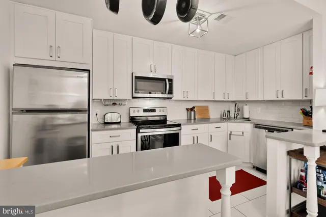 a kitchen with granite countertop a refrigerator stove and microwave