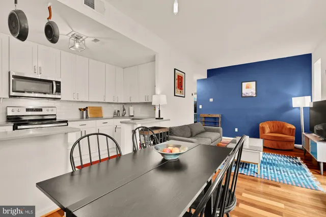 a kitchen with stainless steel appliances granite countertop a table chairs microwave and sink