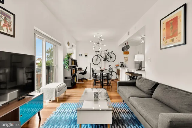 a living room with furniture a flat screen tv and a window
