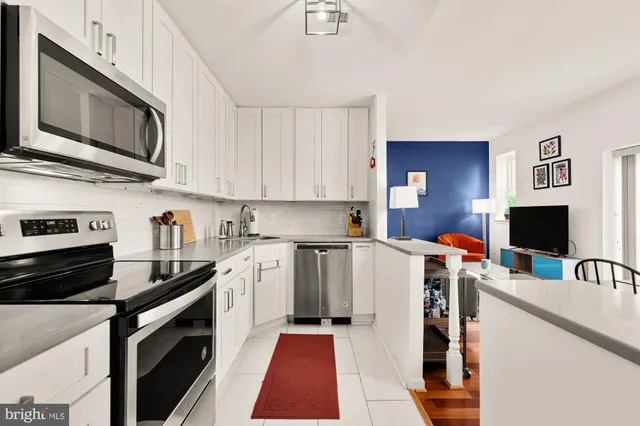 a kitchen with stainless steel appliances a stove microwave and sink