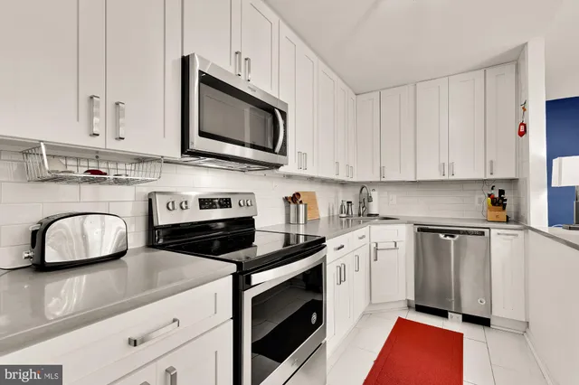 a kitchen with granite countertop a stove a sink and a microwave