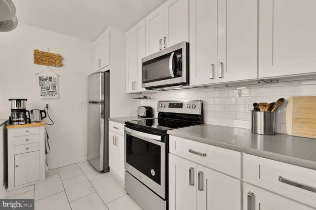 a kitchen with white cabinets and stainless steel appliances