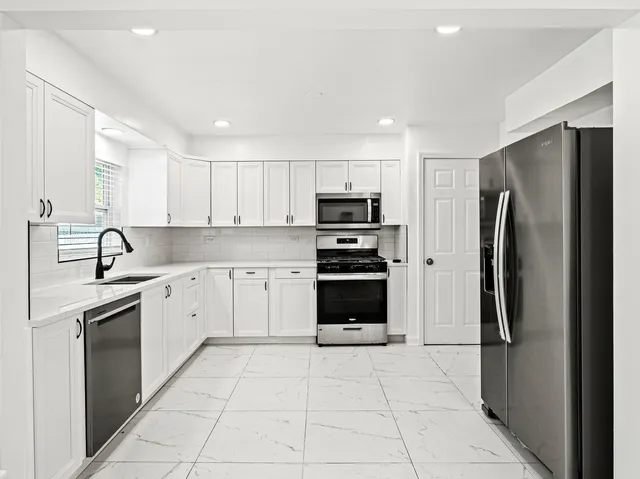 a kitchen with stainless steel appliances granite countertop a refrigerator sink and stove