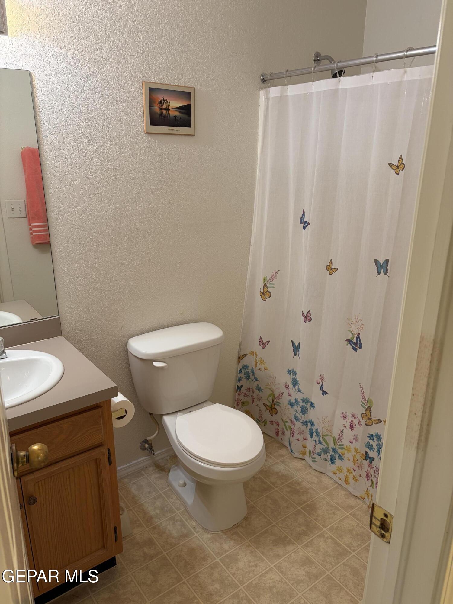 10735 Thunder Road El Paso, TX 79927 - Photo 11 of 32 a white toilet sitting next to a shower curtain