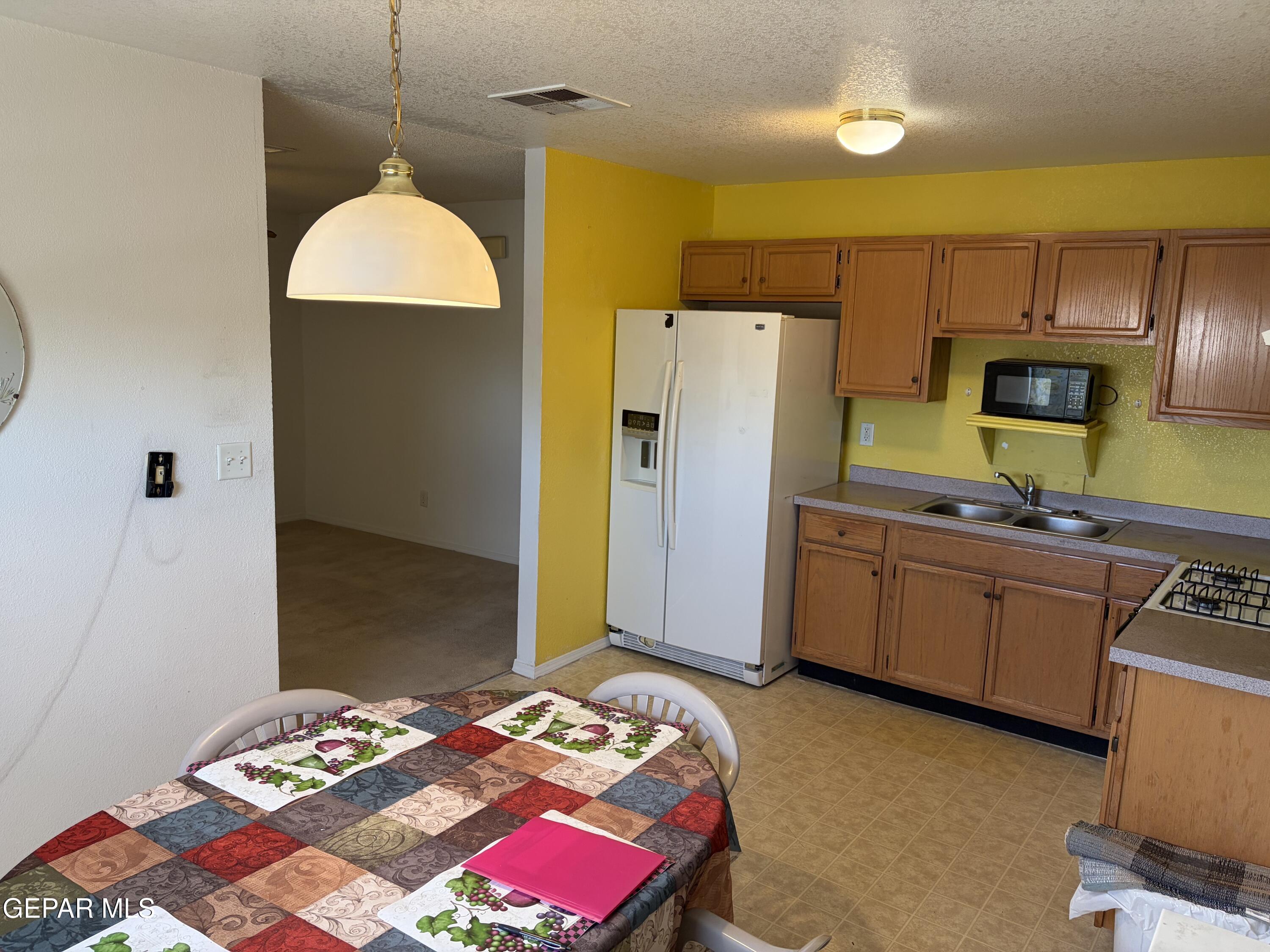 10735 Thunder Road El Paso, TX 79927 - Photo 4 of 32 a bedroom with a bed and a refrigerator