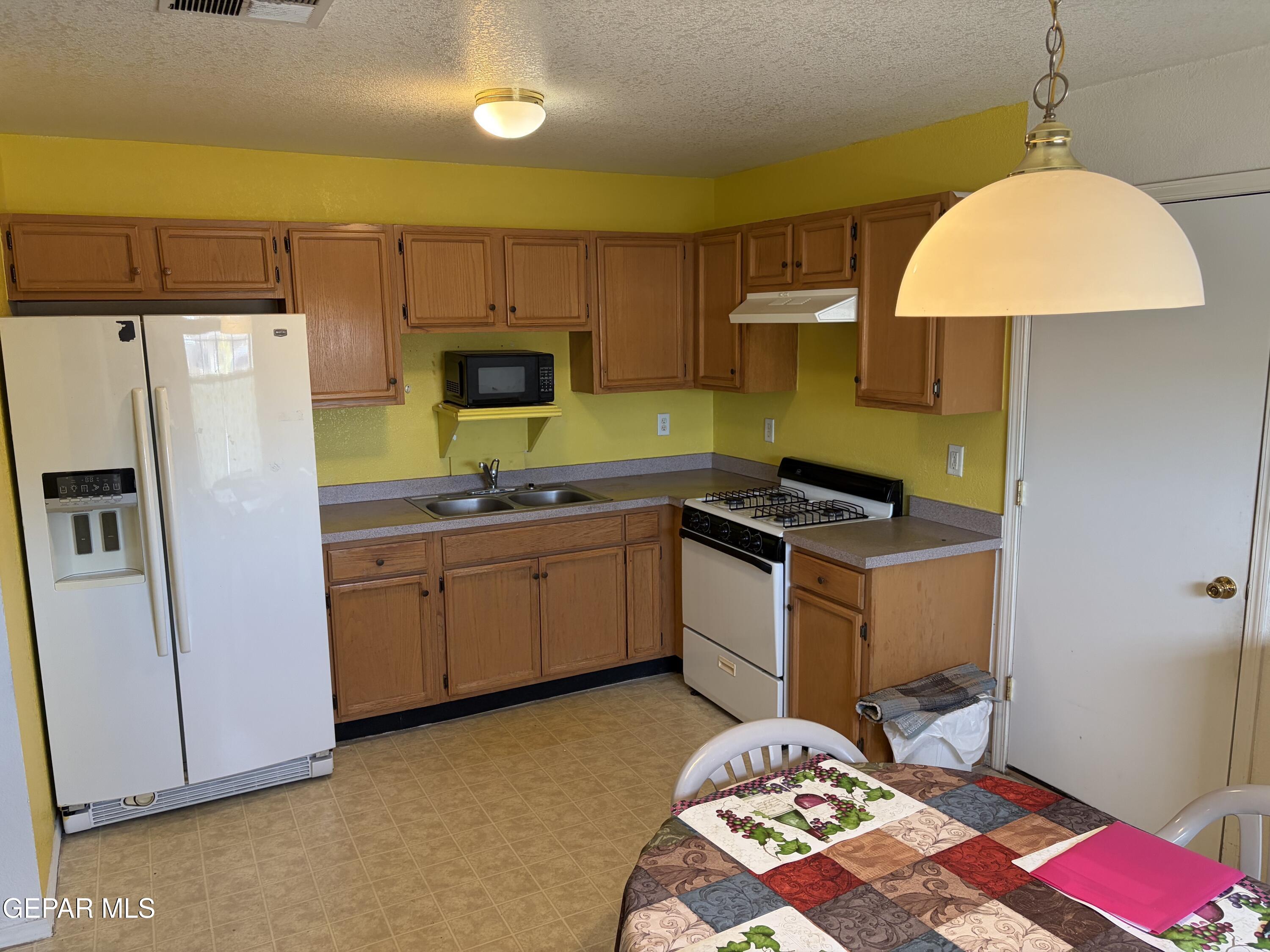 10735 Thunder Road El Paso, TX 79927 - Photo 5 of 32 a kitchen with a sink stove and refrigerator